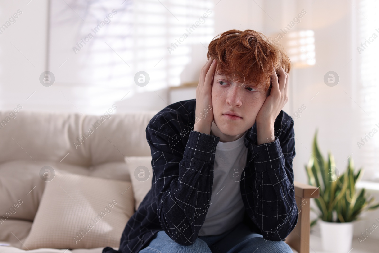 Teen problems. Depressed teenage boy on sofa at home, space for text Photo of Teen problems. Depressed teenage boy on sofa at home, space for text
