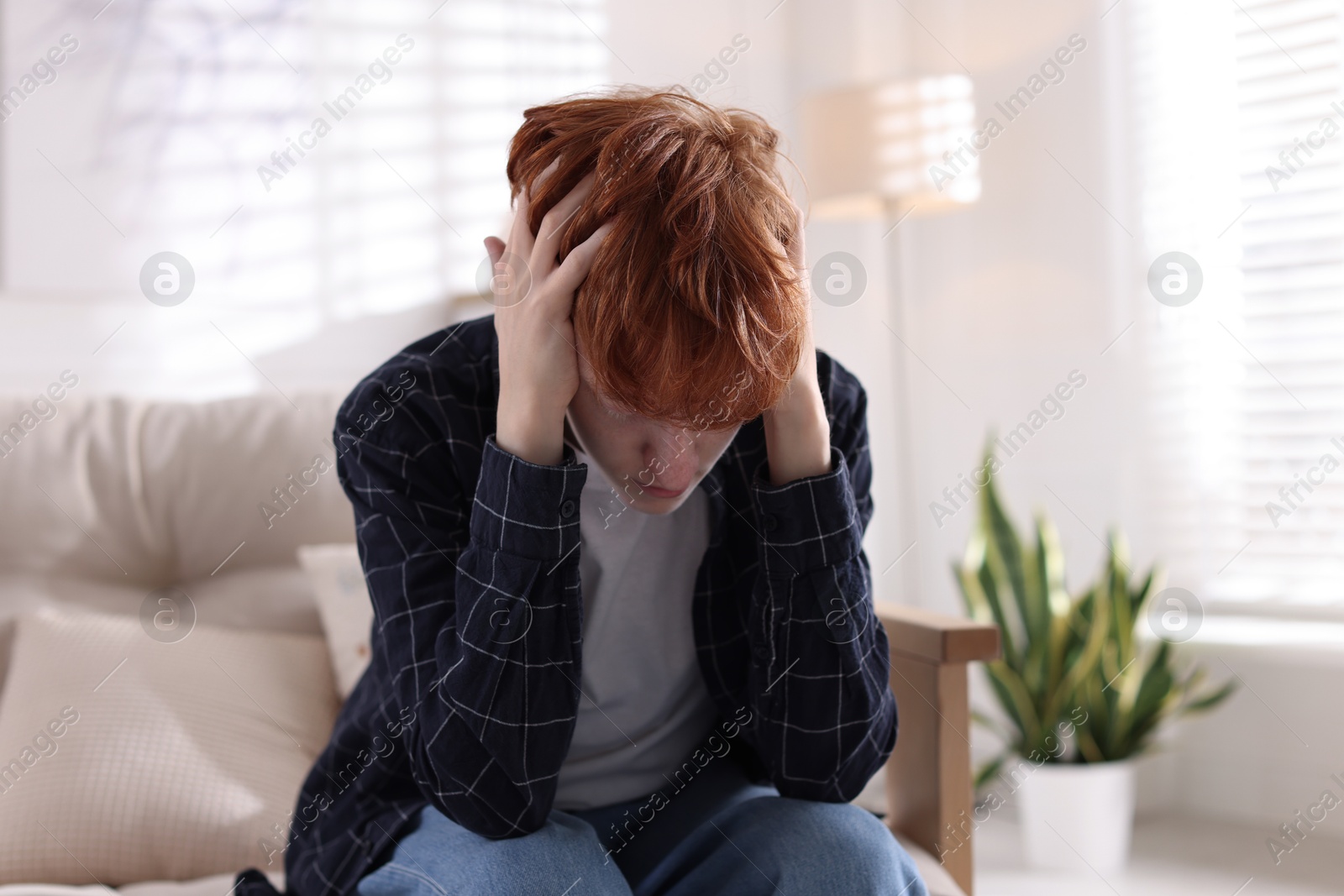 Teen problems. Depressed teenage boy on sofa at home Photo of Teen problems. Depressed teenage boy on sofa at home