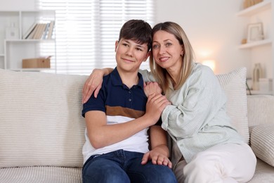 Photo of Mother and her son on sofa at home