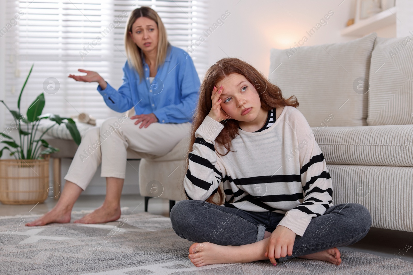 Teenage daughter ignoring her mother at home, selective focus Photo of Teenage daughter ignoring her mother at home, selective focus