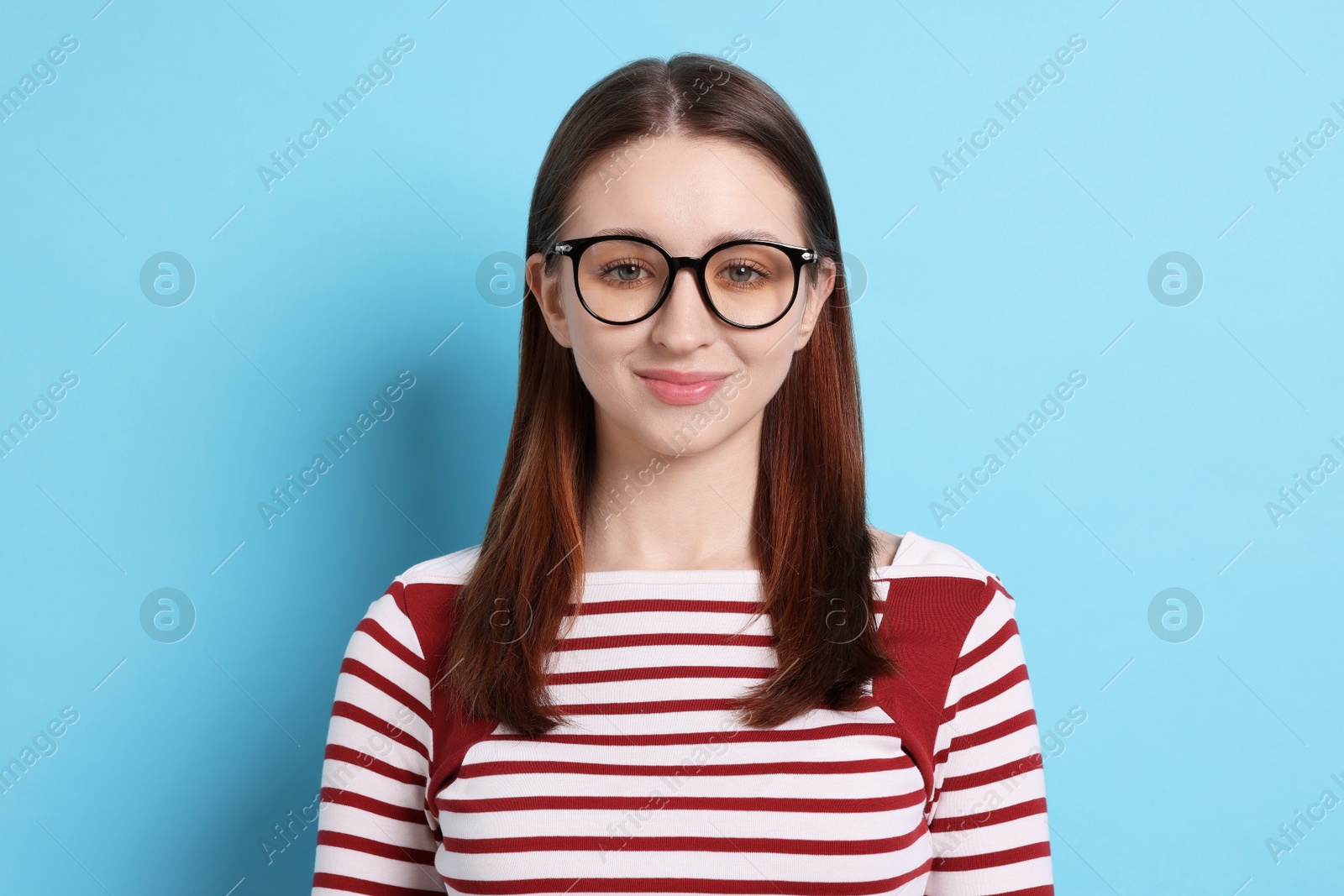 Photo of Teenage girl in glasses on light blue background