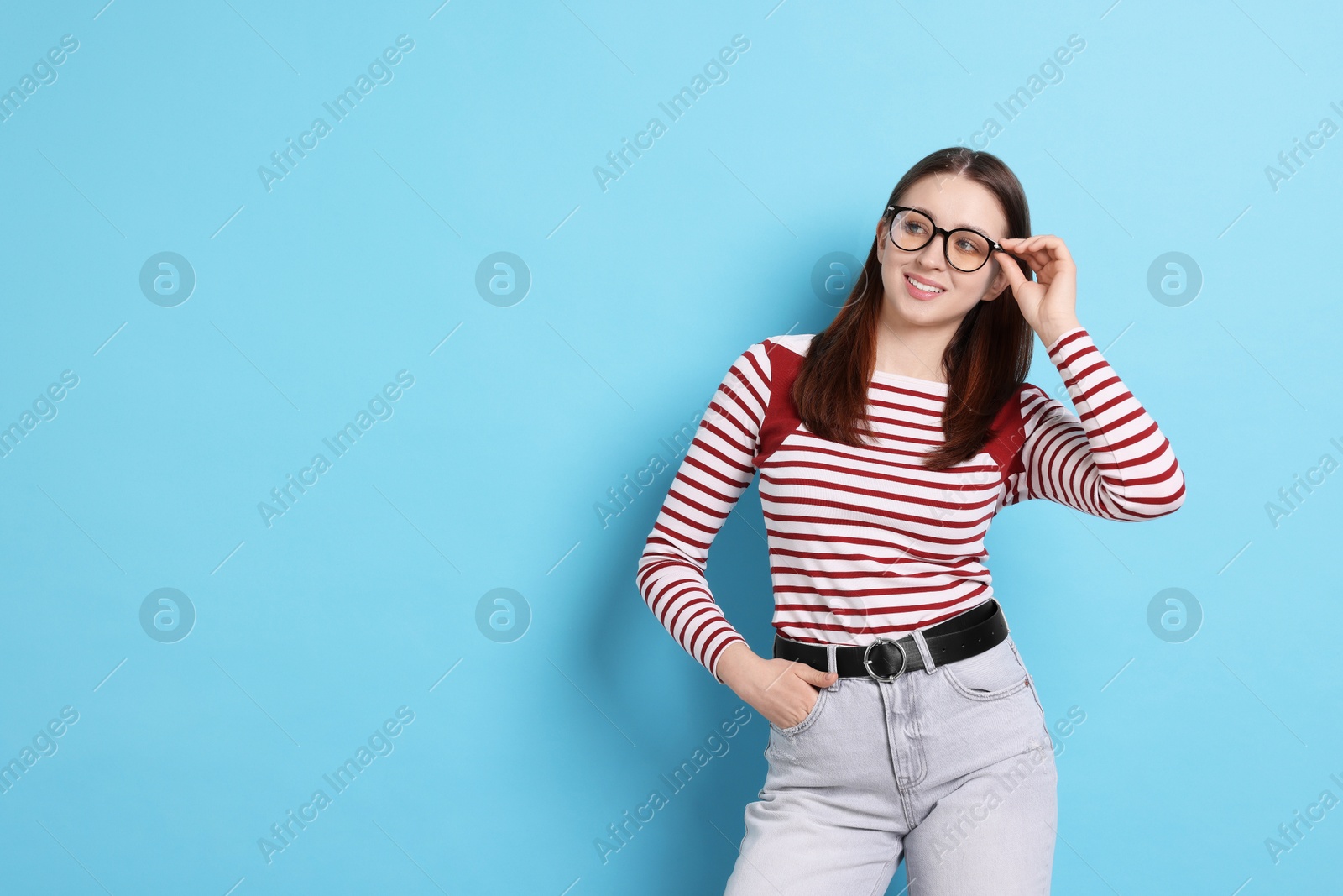 Teenage girl in glasses on light blue background, space for text Photo of Teenage girl in glasses on light blue background, space for text