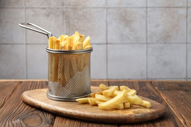 Photo of Tasty french fried served on wooden table, closeup
