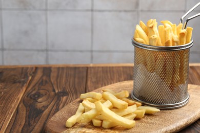 Photo of Tasty french fried served on wooden table, closeup. Space for text