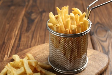 Photo of Tasty french fried served on wooden table, closeup