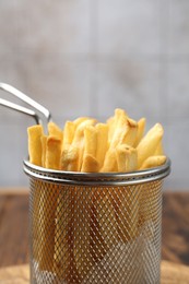 Photo of Tasty french fried served on wooden table, closeup