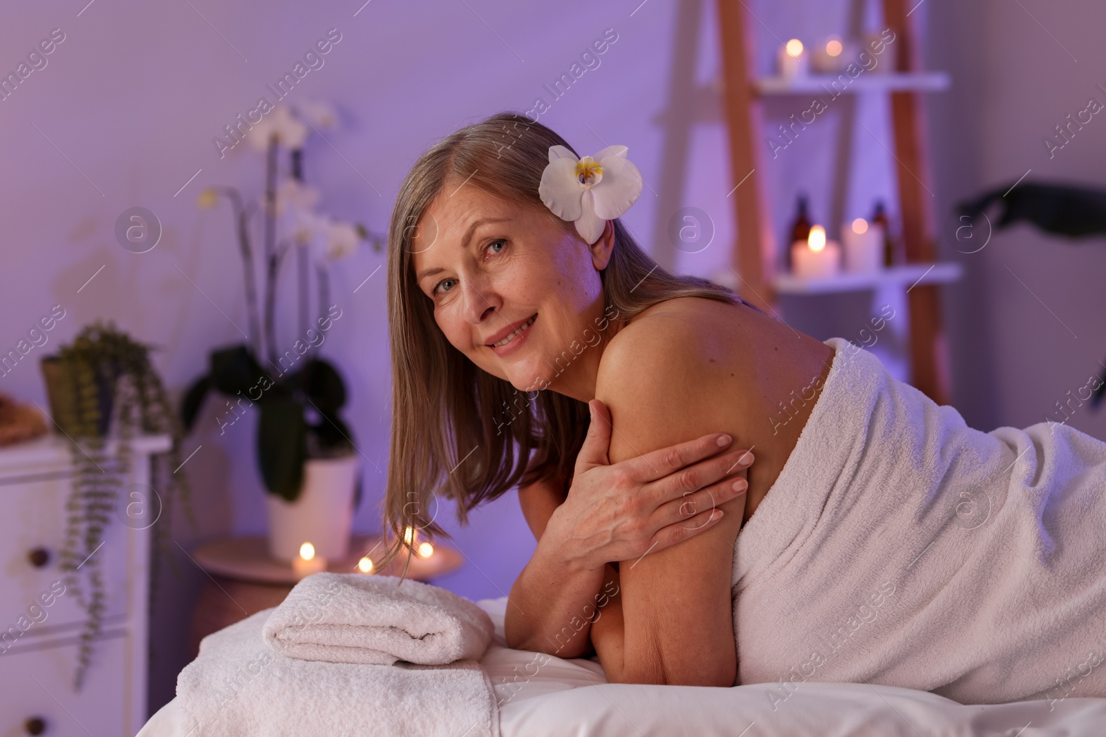 Senior woman relaxing on massage couch in spa salon Photo of Senior woman relaxing on massage couch in spa salon