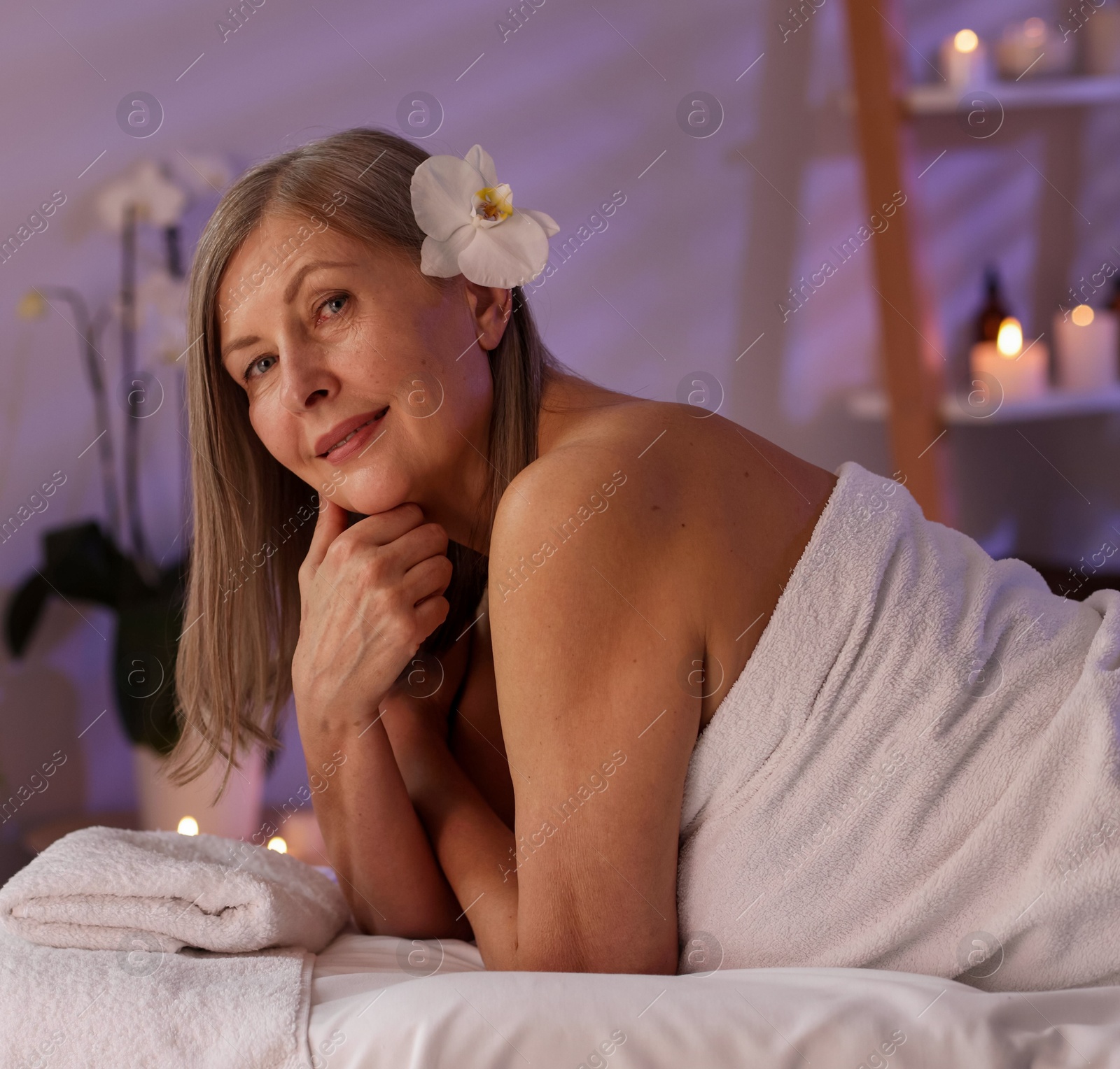 Senior woman relaxing on massage couch in spa salon Photo of Senior woman relaxing on massage couch in spa salon