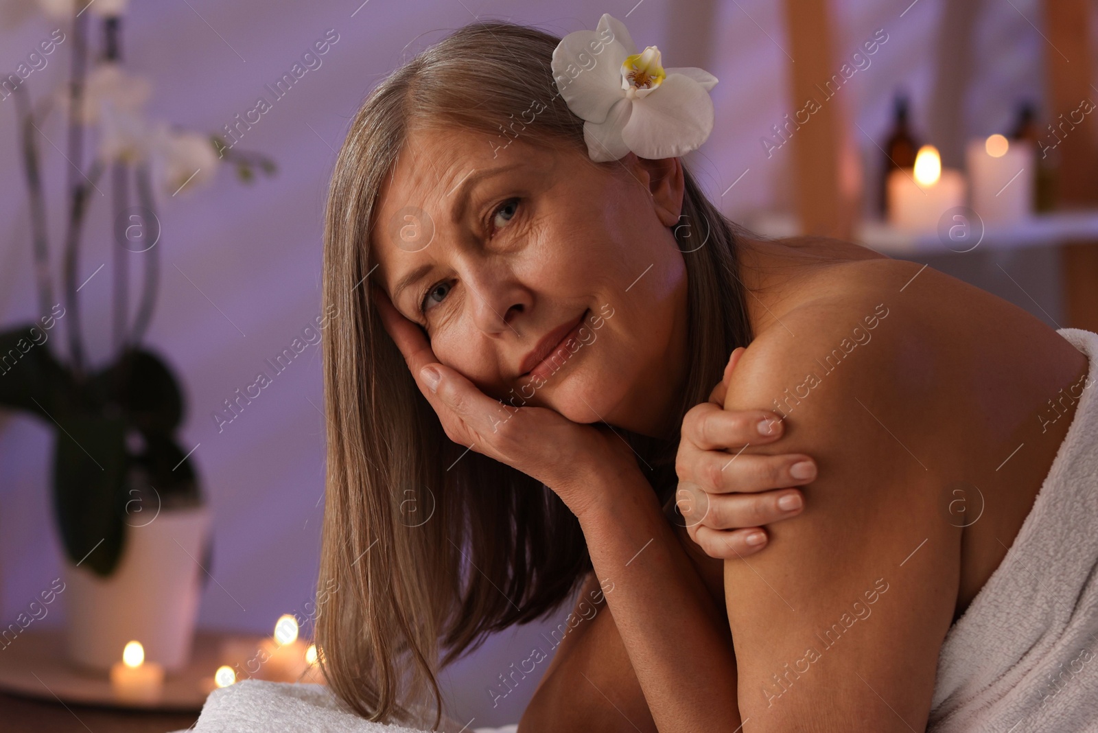 Senior woman relaxing on massage couch in spa salon Photo of Senior woman relaxing on massage couch in spa salon