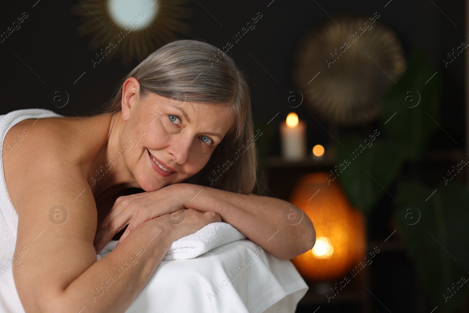 Senior woman relaxing on massage couch in spa salon Photo of Senior woman relaxing on massage couch in spa salon