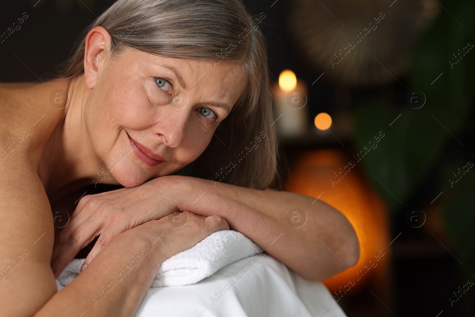 Senior woman relaxing on massage couch in spa salon Photo of Senior woman relaxing on massage couch in spa salon