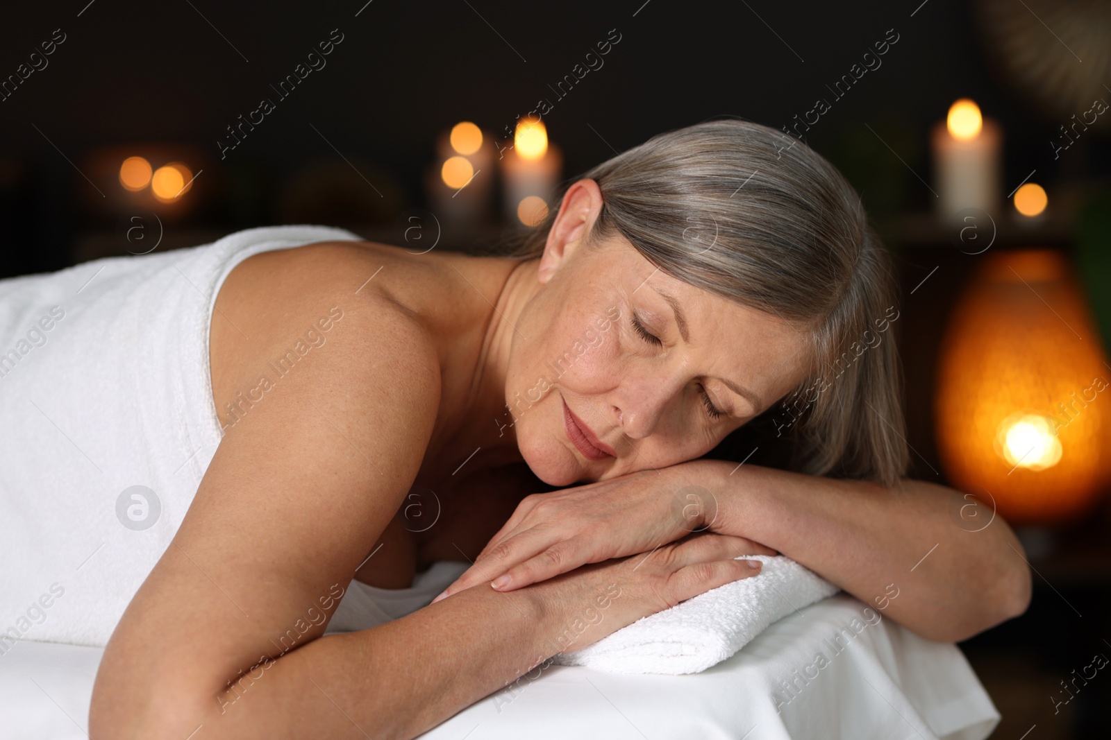 Senior woman relaxing on massage couch in spa salon Photo of Senior woman relaxing on massage couch in spa salon
