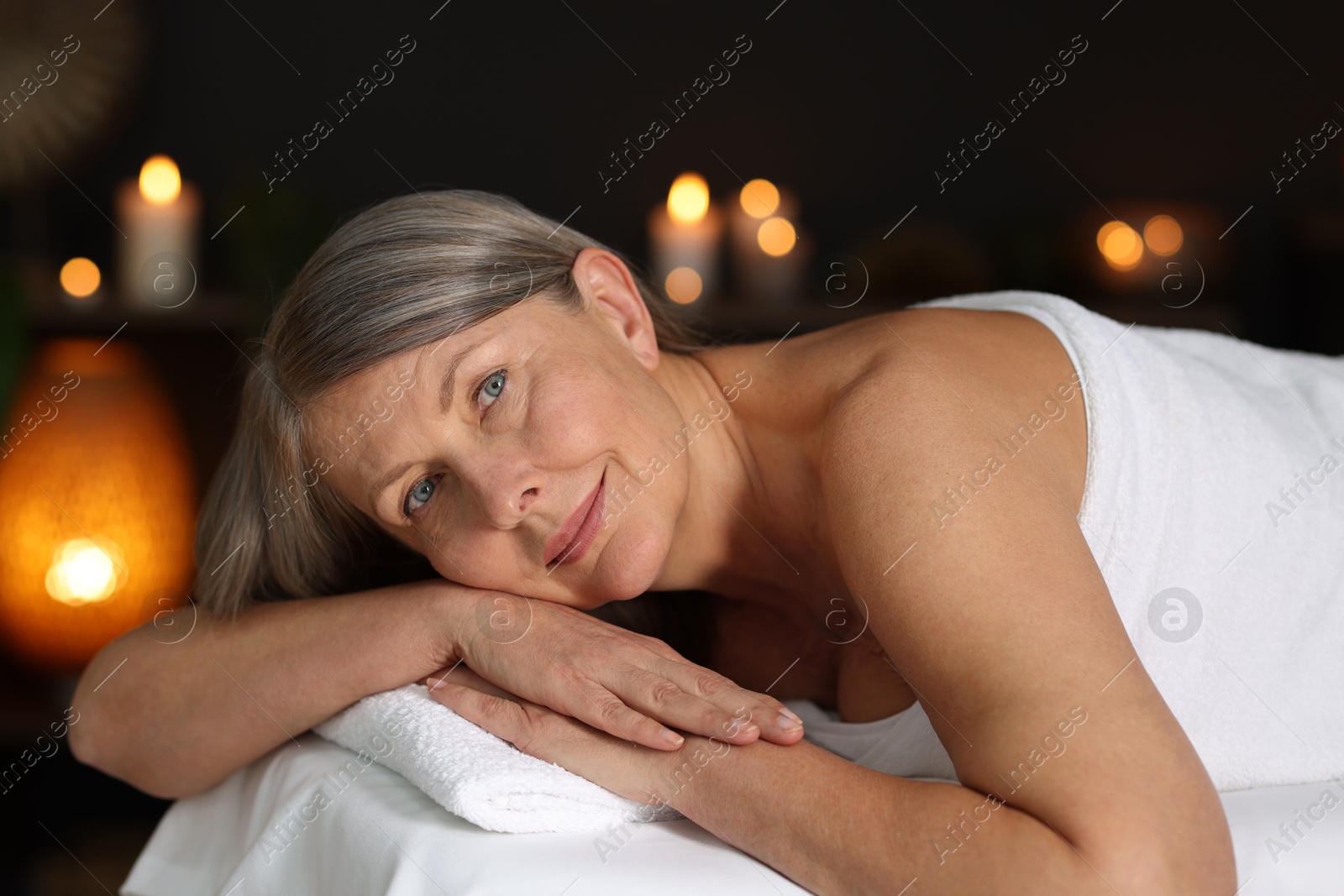Senior woman relaxing on massage couch in spa salon Photo of Senior woman relaxing on massage couch in spa salon