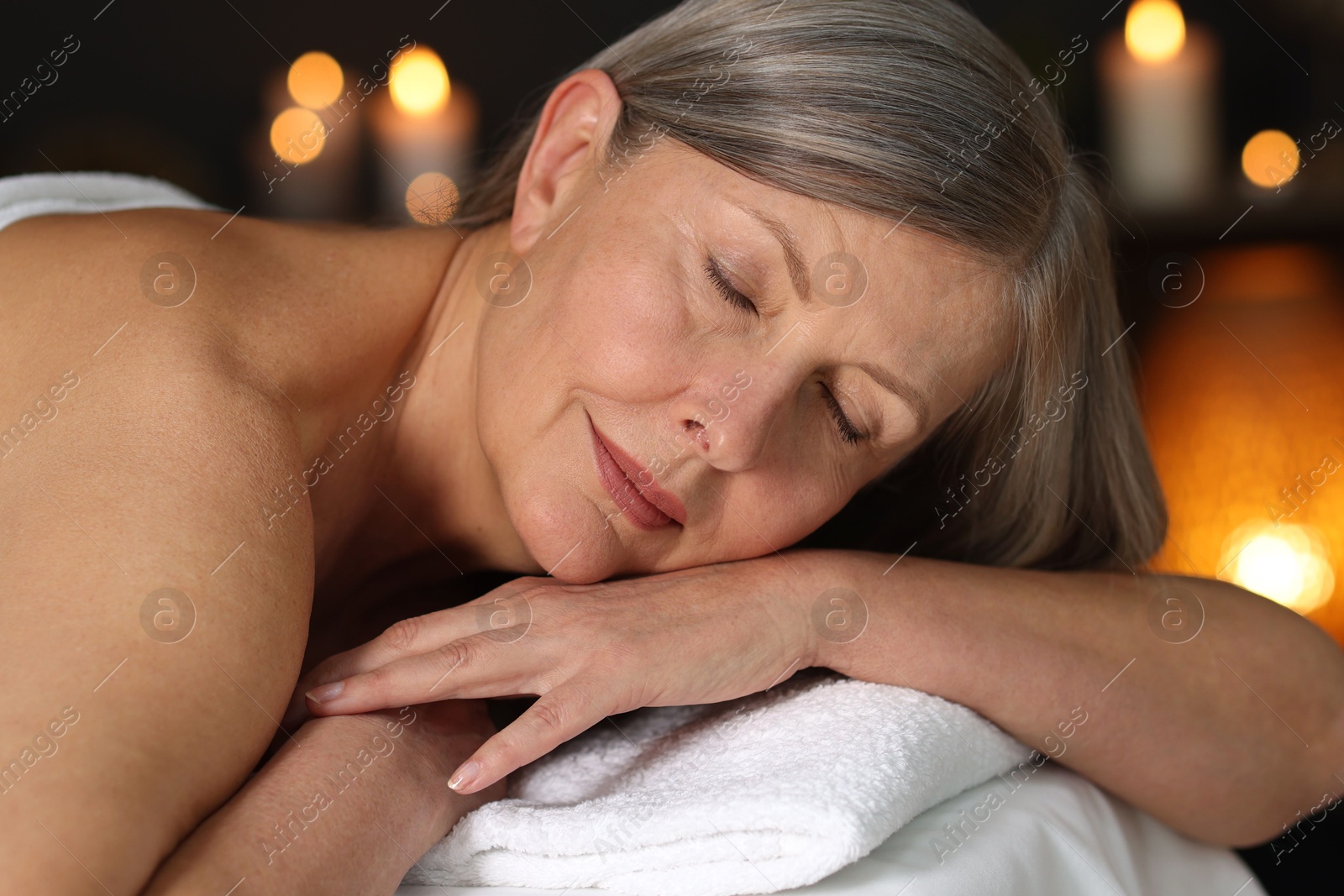 Photo of Senior woman relaxing on massage couch in spa salon, closeup