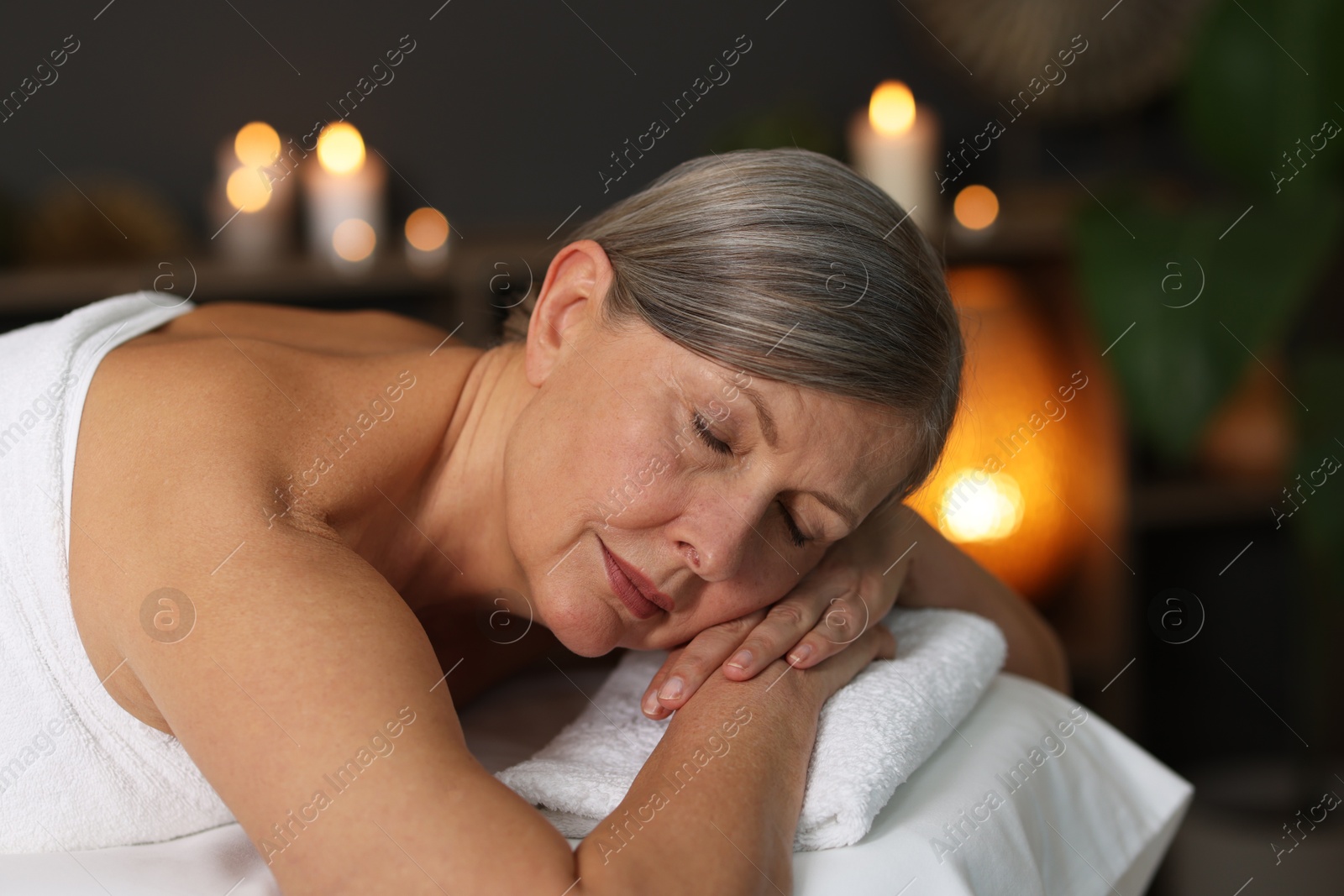 Senior woman relaxing on massage couch in spa salon Photo of Senior woman relaxing on massage couch in spa salon