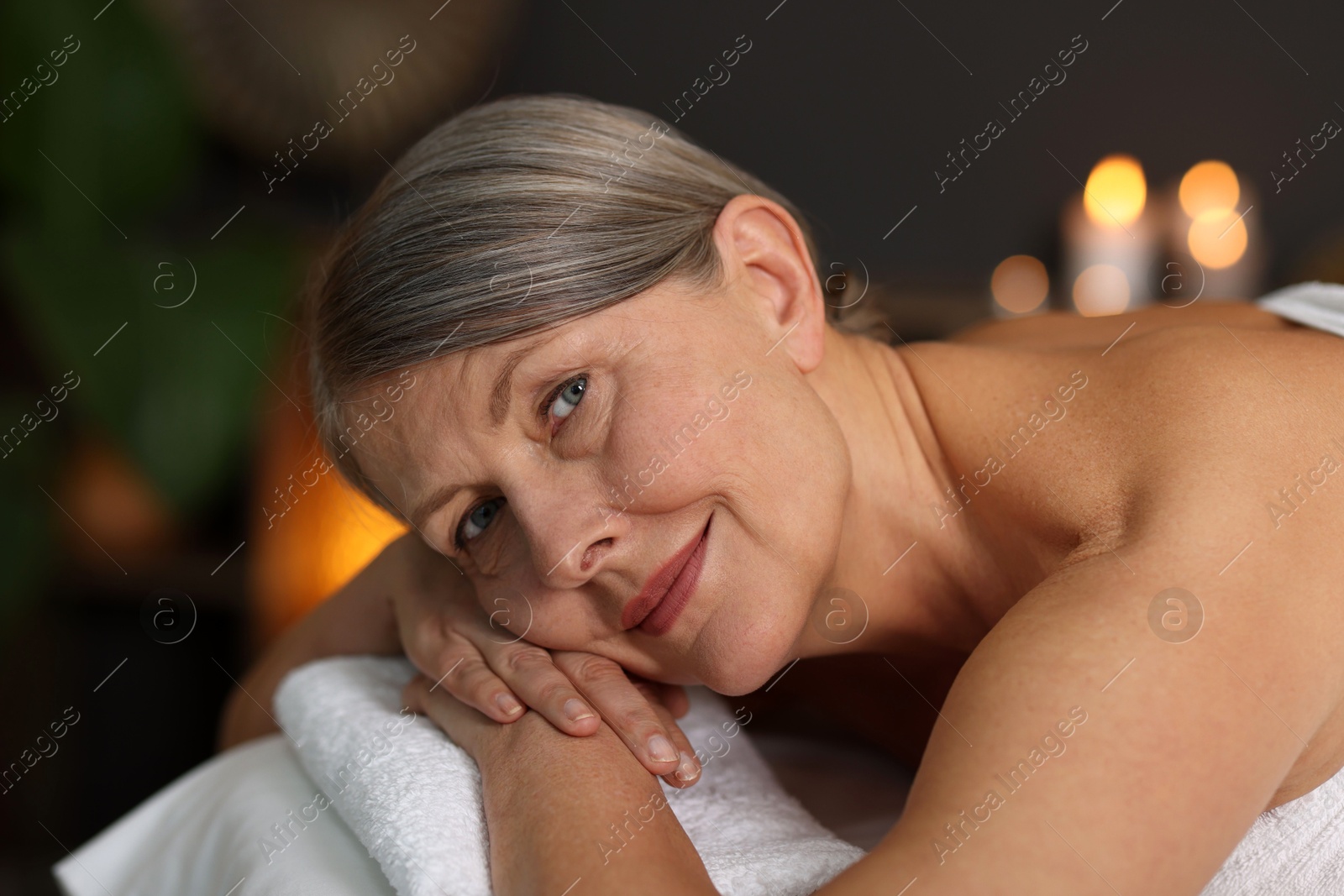 Senior woman relaxing on massage couch in spa salon Photo of Senior woman relaxing on massage couch in spa salon