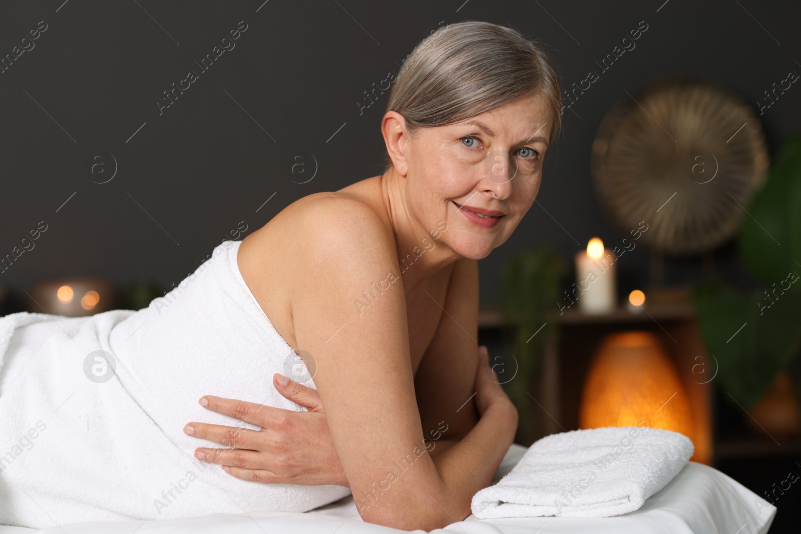 Senior woman relaxing on massage couch in spa salon Photo of Senior woman relaxing on massage couch in spa salon
