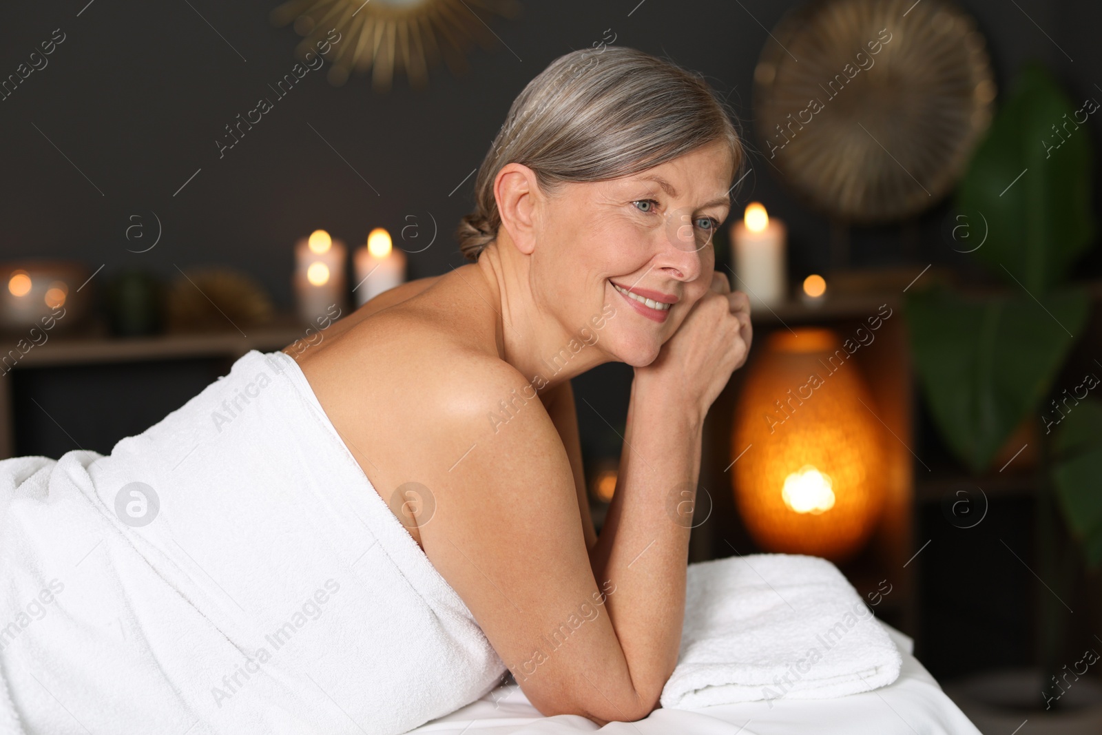 Senior woman relaxing on massage couch in spa salon Photo of Senior woman relaxing on massage couch in spa salon