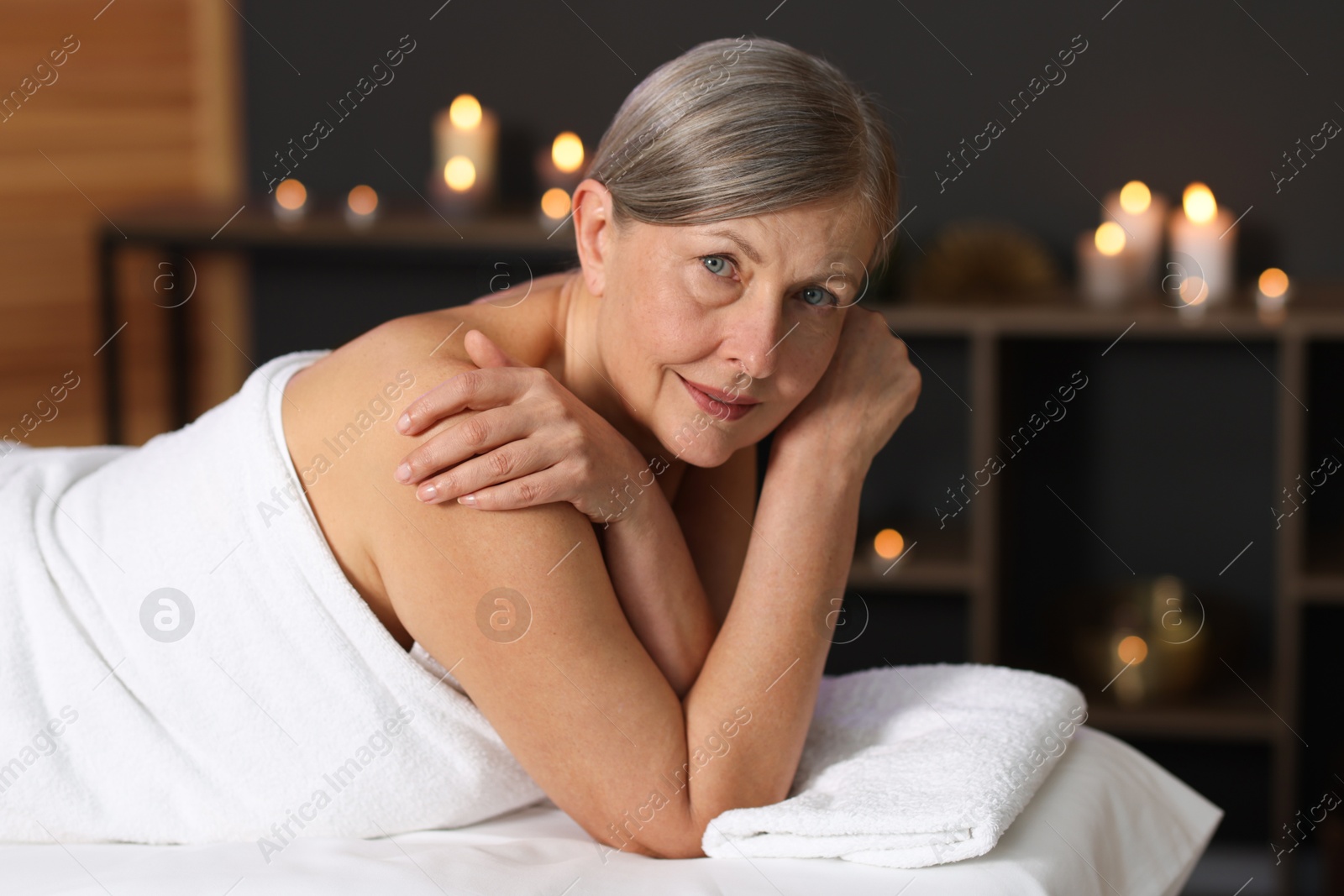 Senior woman relaxing on massage couch in spa salon Photo of Senior woman relaxing on massage couch in spa salon