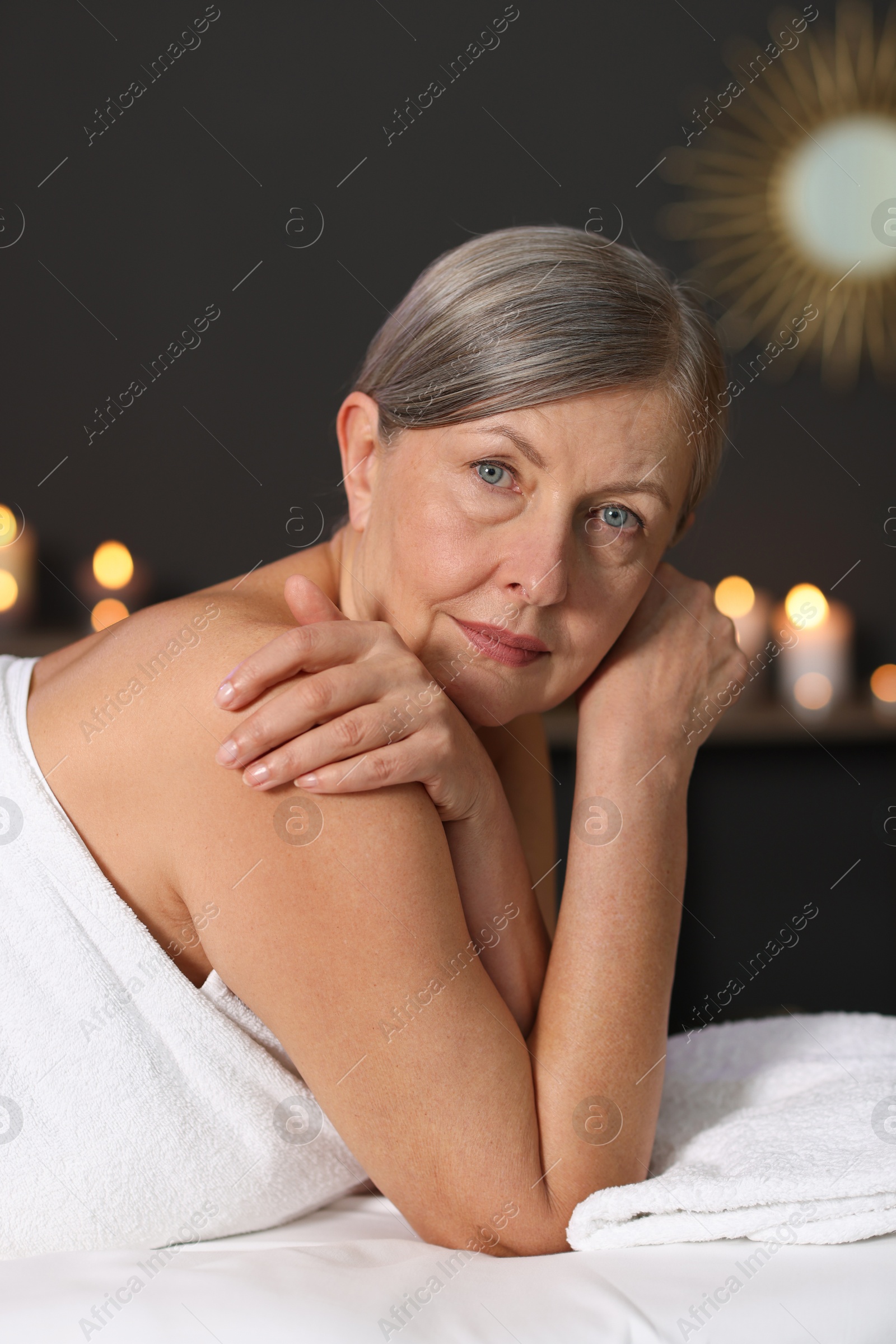 Senior woman relaxing on massage couch in spa salon Photo of Senior woman relaxing on massage couch in spa salon