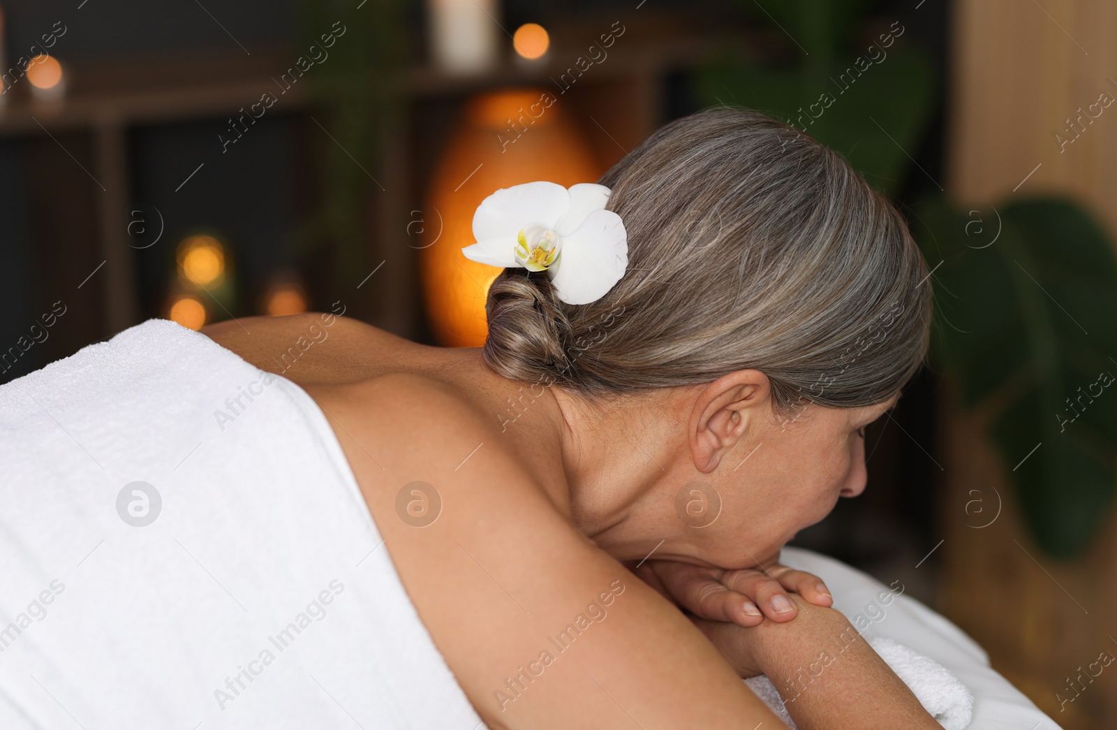 Senior woman relaxing on massage couch in spa salon Photo of Senior woman relaxing on massage couch in spa salon