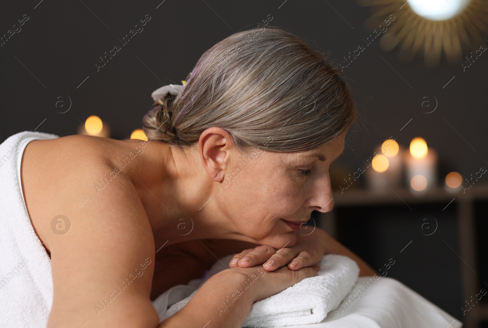 Senior woman relaxing on massage couch in spa salon Photo of Senior woman relaxing on massage couch in spa salon