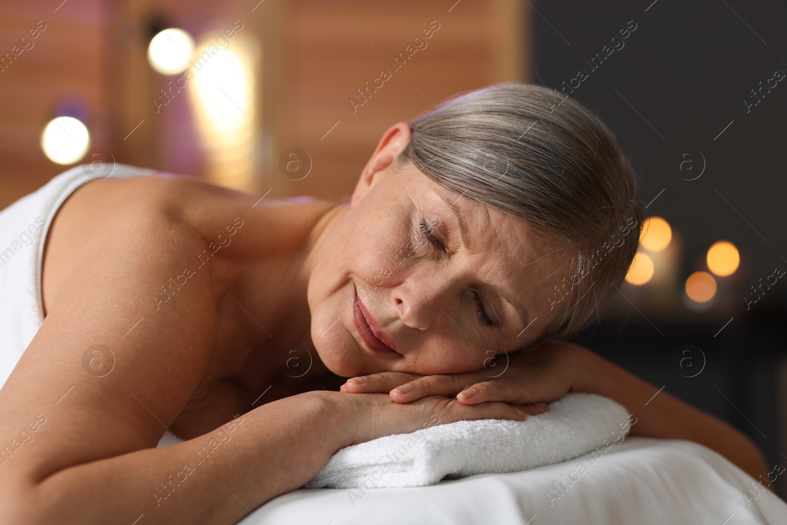 Senior woman relaxing on massage couch in spa salon Photo of Senior woman relaxing on massage couch in spa salon