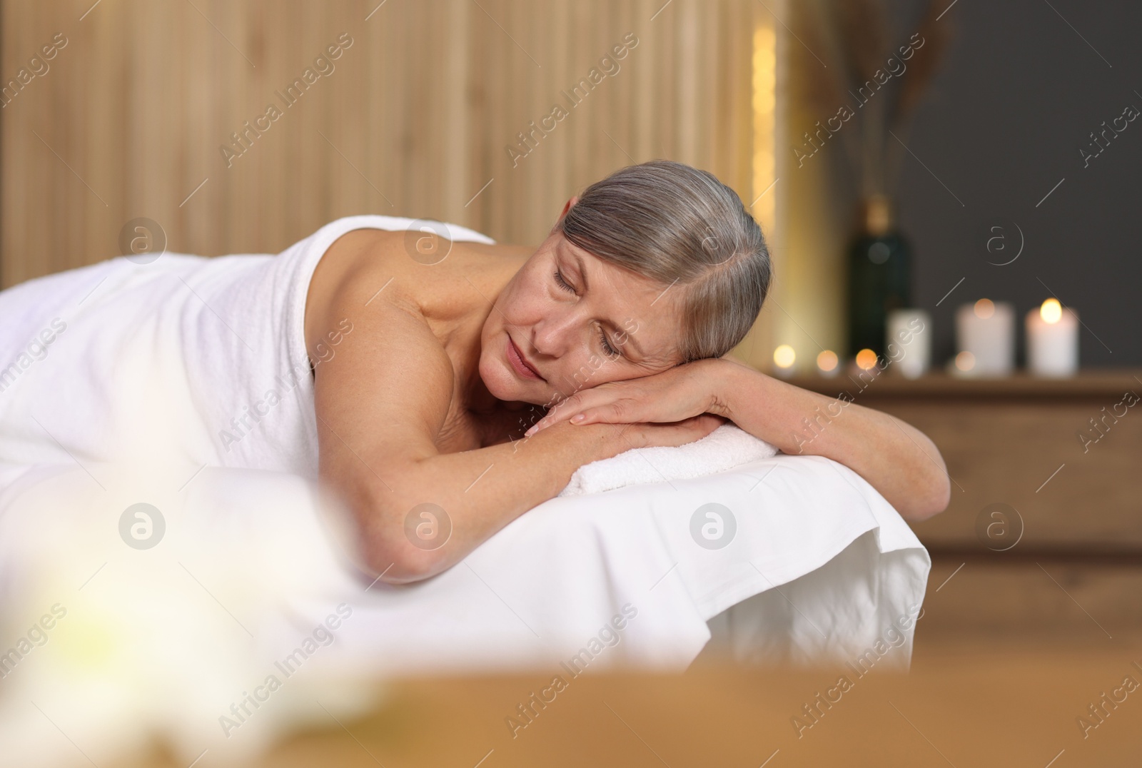 Senior woman relaxing on massage couch in spa salon Photo of Senior woman relaxing on massage couch in spa salon