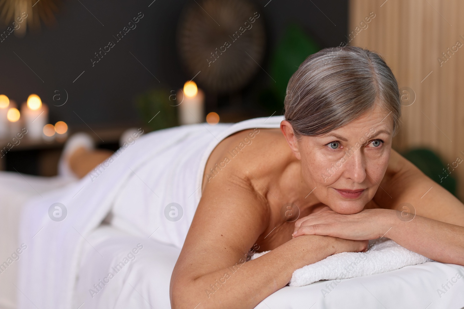 Senior woman relaxing on massage couch in spa salon Photo of Senior woman relaxing on massage couch in spa salon