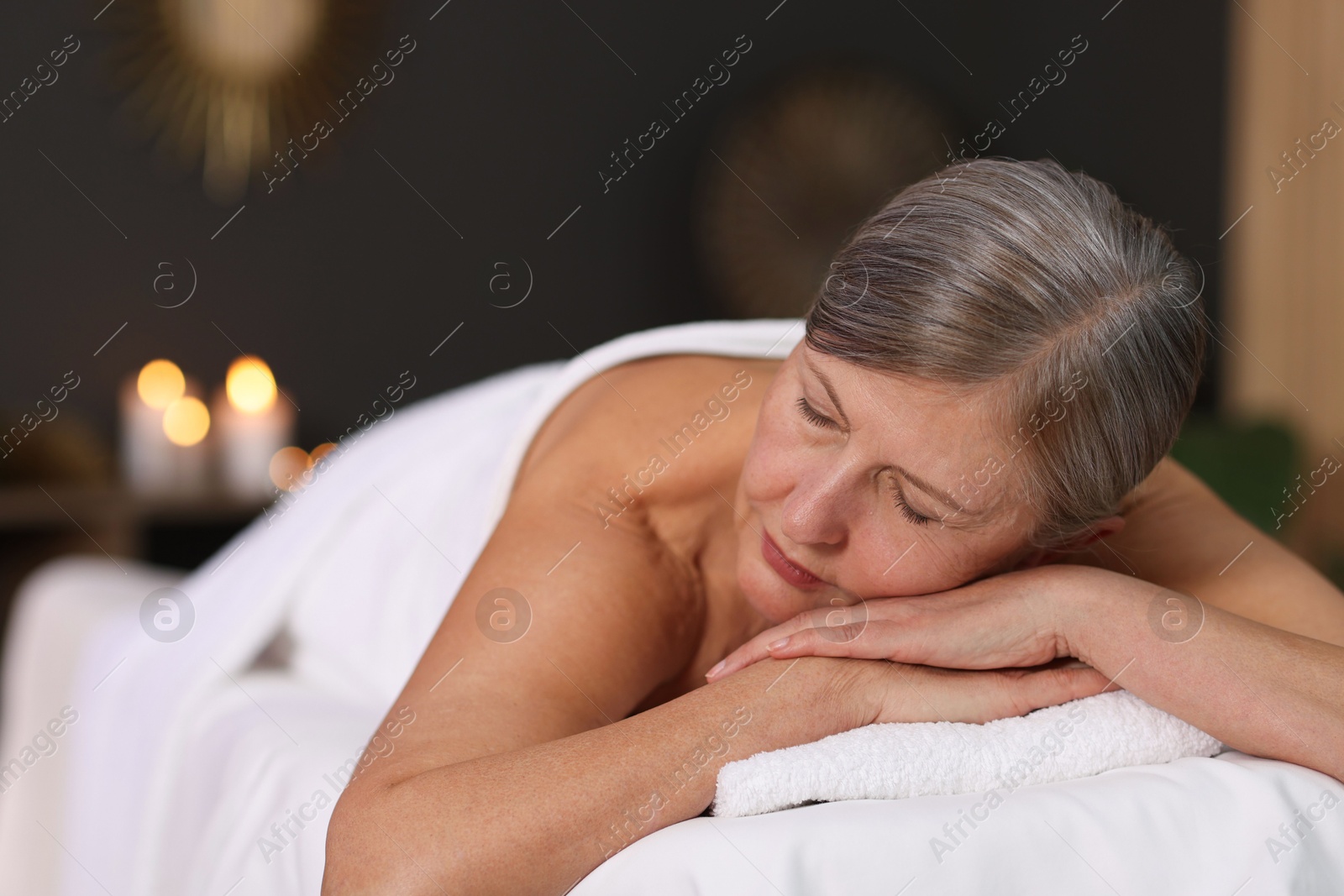 Senior woman relaxing on massage couch in spa salon Photo of Senior woman relaxing on massage couch in spa salon