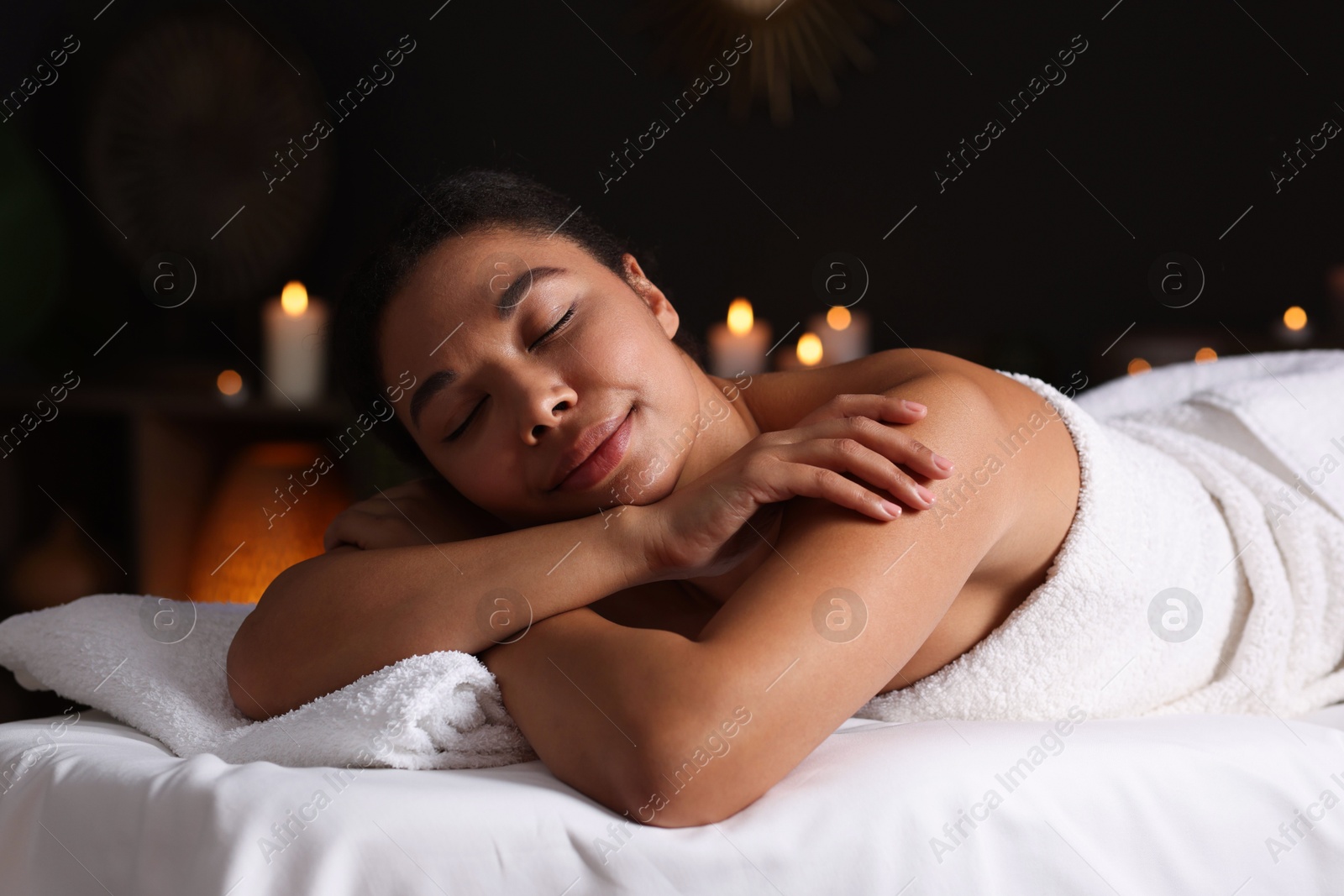 Photo of Beautiful woman relaxing on massage couch in spa salon