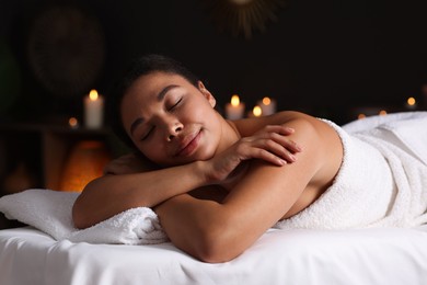 Photo of Beautiful woman relaxing on massage couch in spa salon