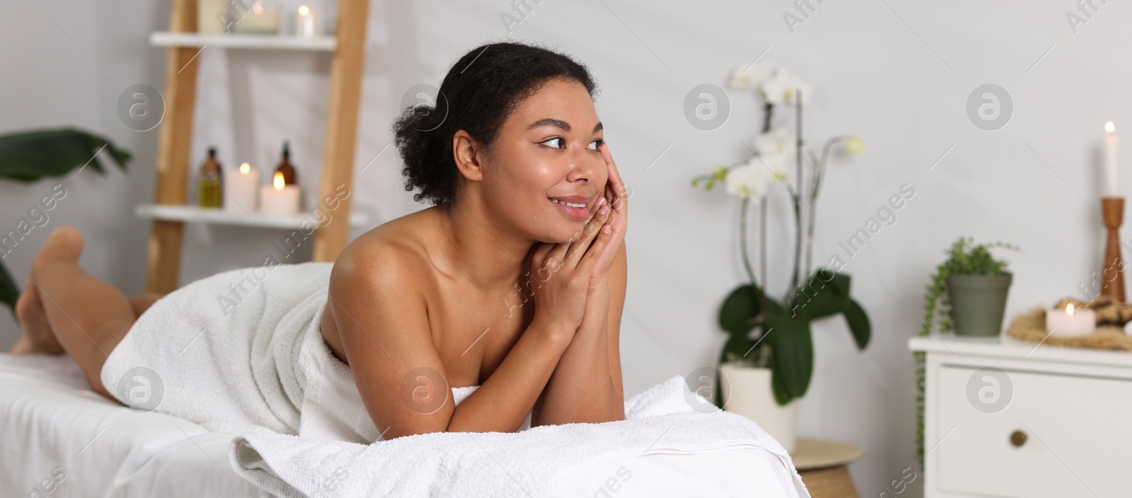 Beautiful woman relaxing on massage couch in spa salon Photo of Beautiful woman relaxing on massage couch in spa salon