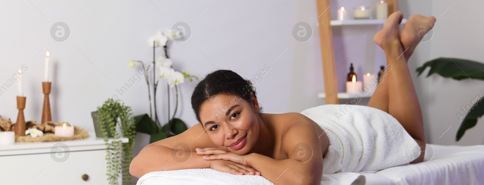 Beautiful woman relaxing on massage couch in spa salon Photo of Beautiful woman relaxing on massage couch in spa salon