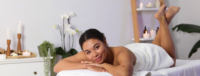 Photo of Beautiful woman relaxing on massage couch in spa salon