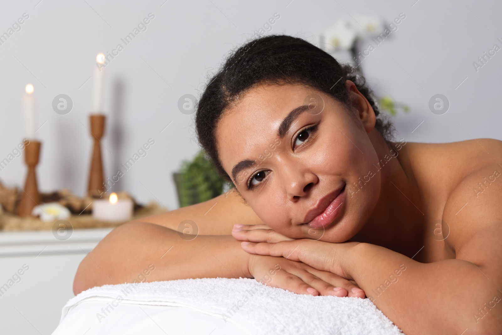 Photo of Beautiful woman relaxing on massage couch in spa salon