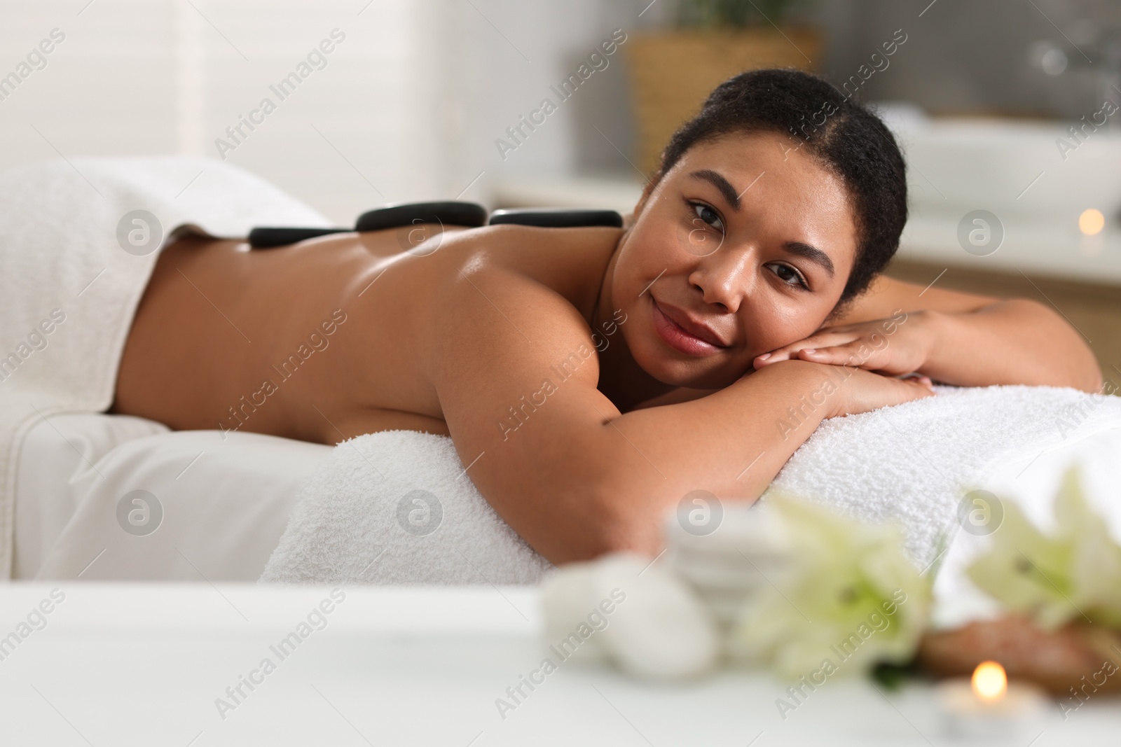 Beautiful woman relaxing on massage couch in spa salon Photo of Beautiful woman relaxing on massage couch in spa salon