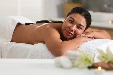 Photo of Beautiful woman relaxing on massage couch in spa salon