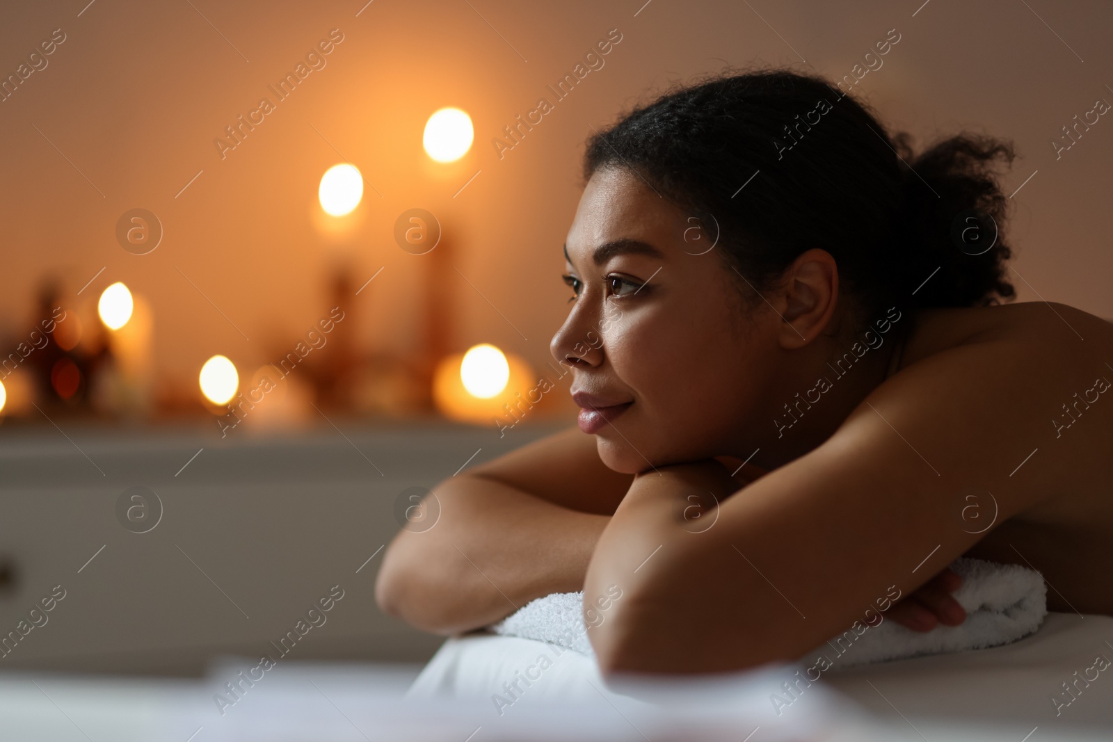 Beautiful woman relaxing on massage couch in spa salon, space for text Photo of Beautiful woman relaxing on massage couch in spa salon, space for text