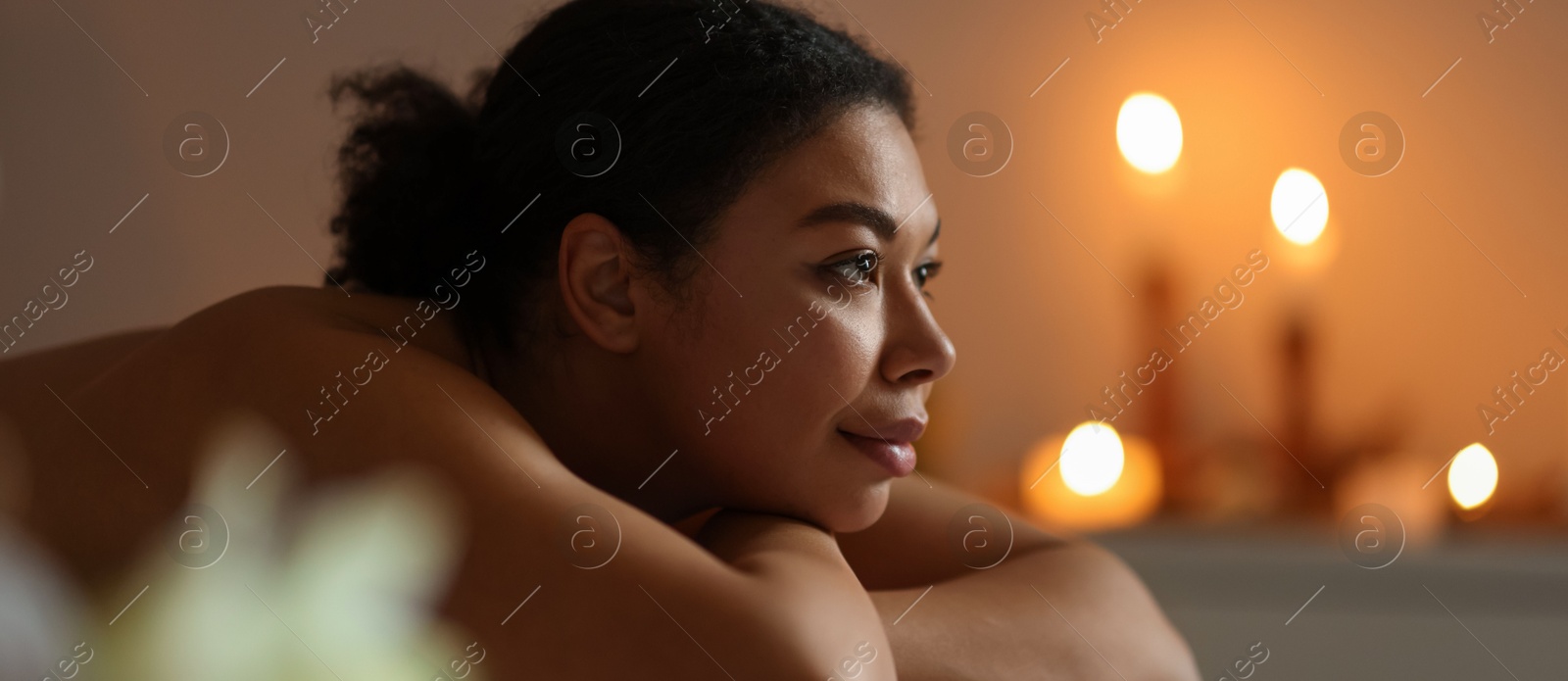 Beautiful woman relaxing on massage couch in spa salon, space for text Photo of Beautiful woman relaxing on massage couch in spa salon, space for text