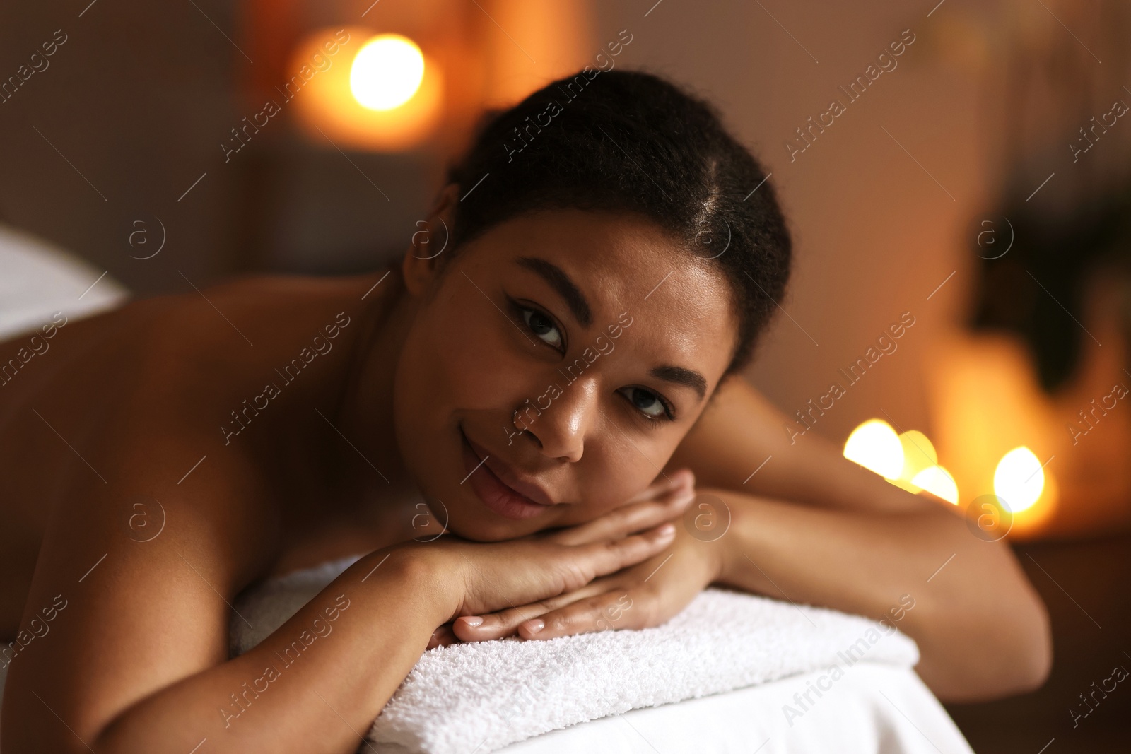 Photo of Beautiful woman relaxing on massage couch in spa salon