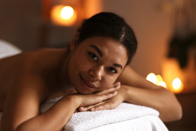 Photo of Beautiful woman relaxing on massage couch in spa salon