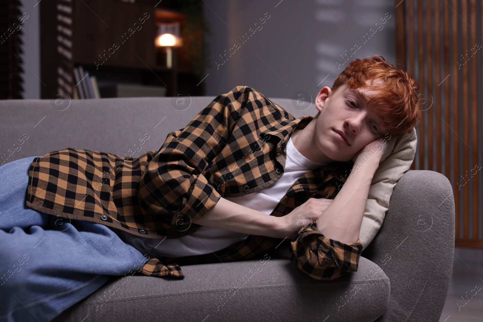 Teen problems. Depressed teenage boy lying on sofa at home Photo of Teen problems. Depressed teenage boy lying on sofa at home