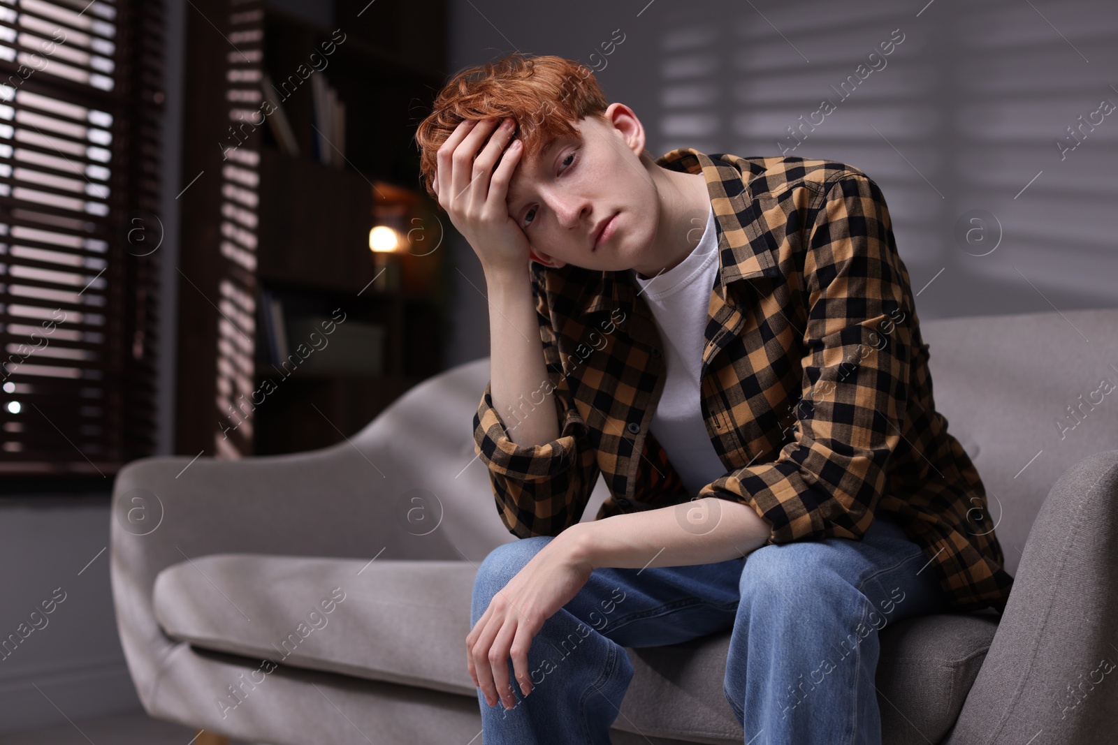 Teen problems. Depressed teenage boy on sofa at home Photo of Teen problems. Depressed teenage boy on sofa at home