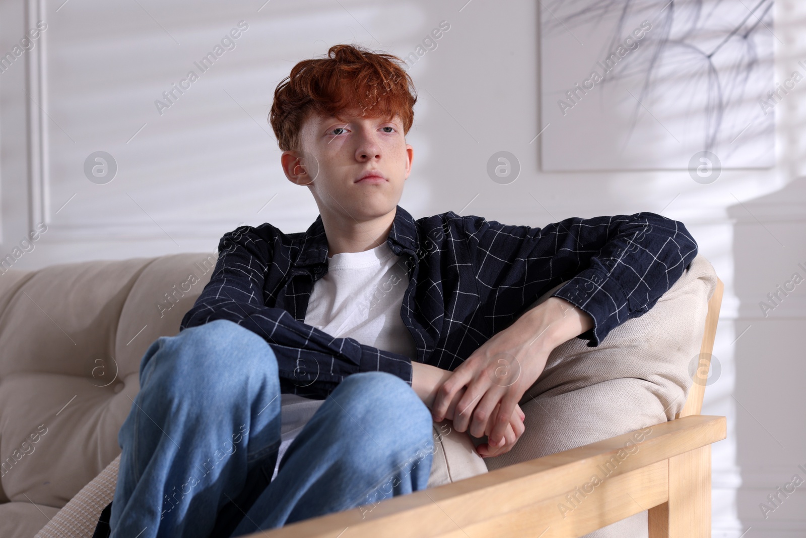 Teen problems. Depressed teenage boy on sofa at home Photo of Teen problems. Depressed teenage boy on sofa at home
