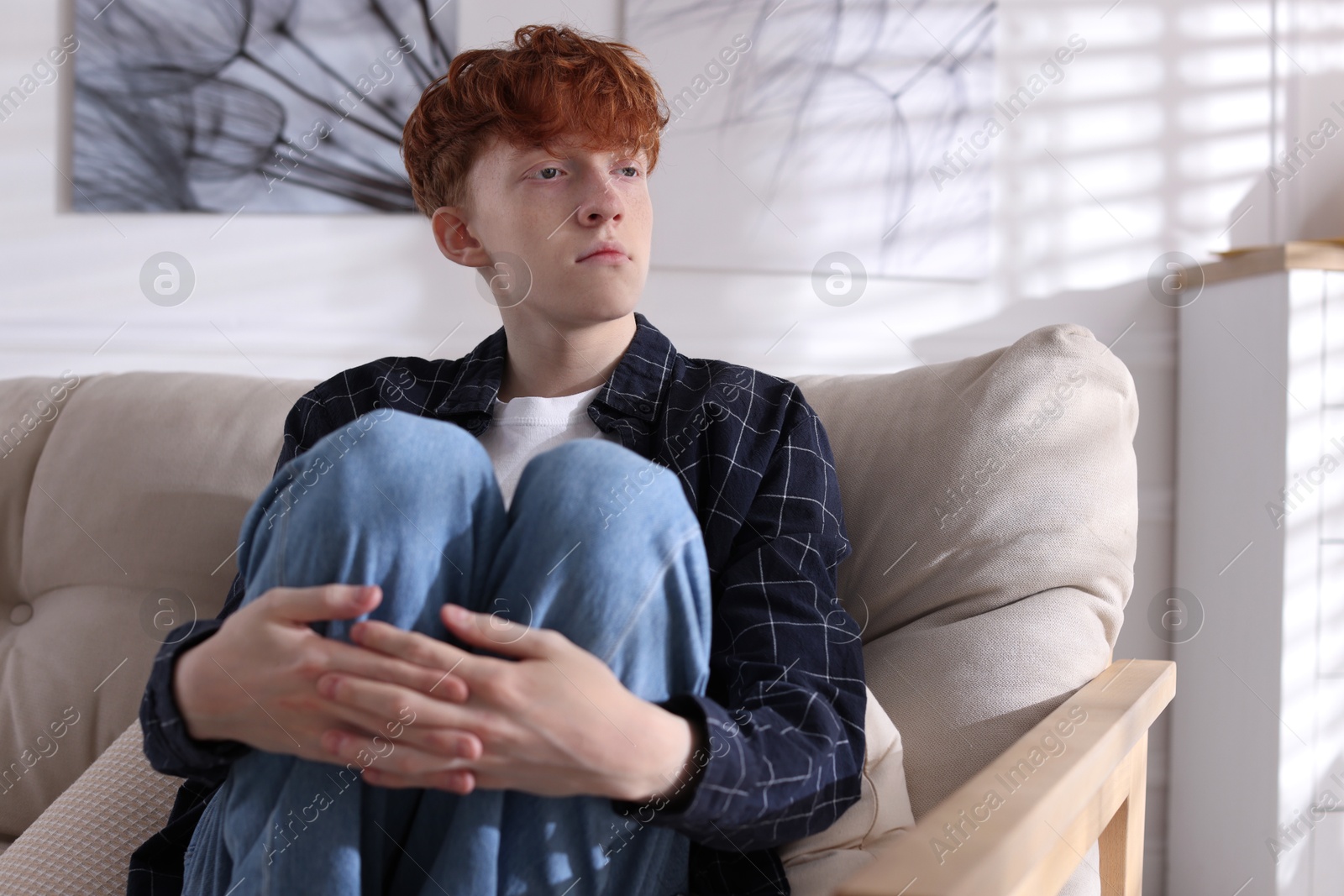 Teen problems. Depressed teenage boy on sofa at home Photo of Teen problems. Depressed teenage boy on sofa at home
