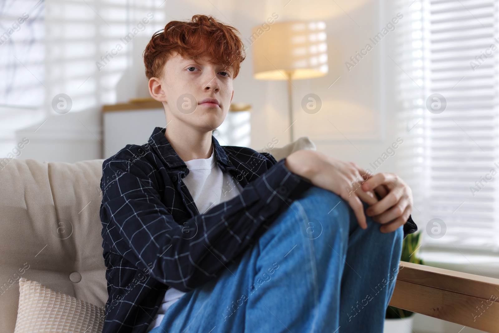 Teen problems. Depressed teenage boy on sofa at home Photo of Teen problems. Depressed teenage boy on sofa at home