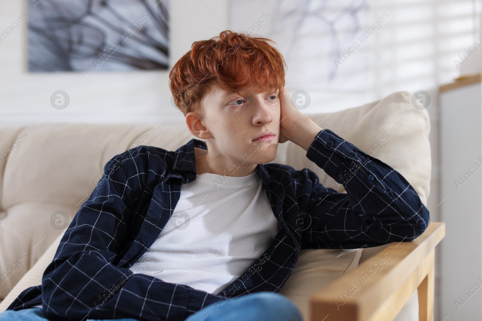 Teen problems. Depressed teenage boy on sofa at home Photo of Teen problems. Depressed teenage boy on sofa at home