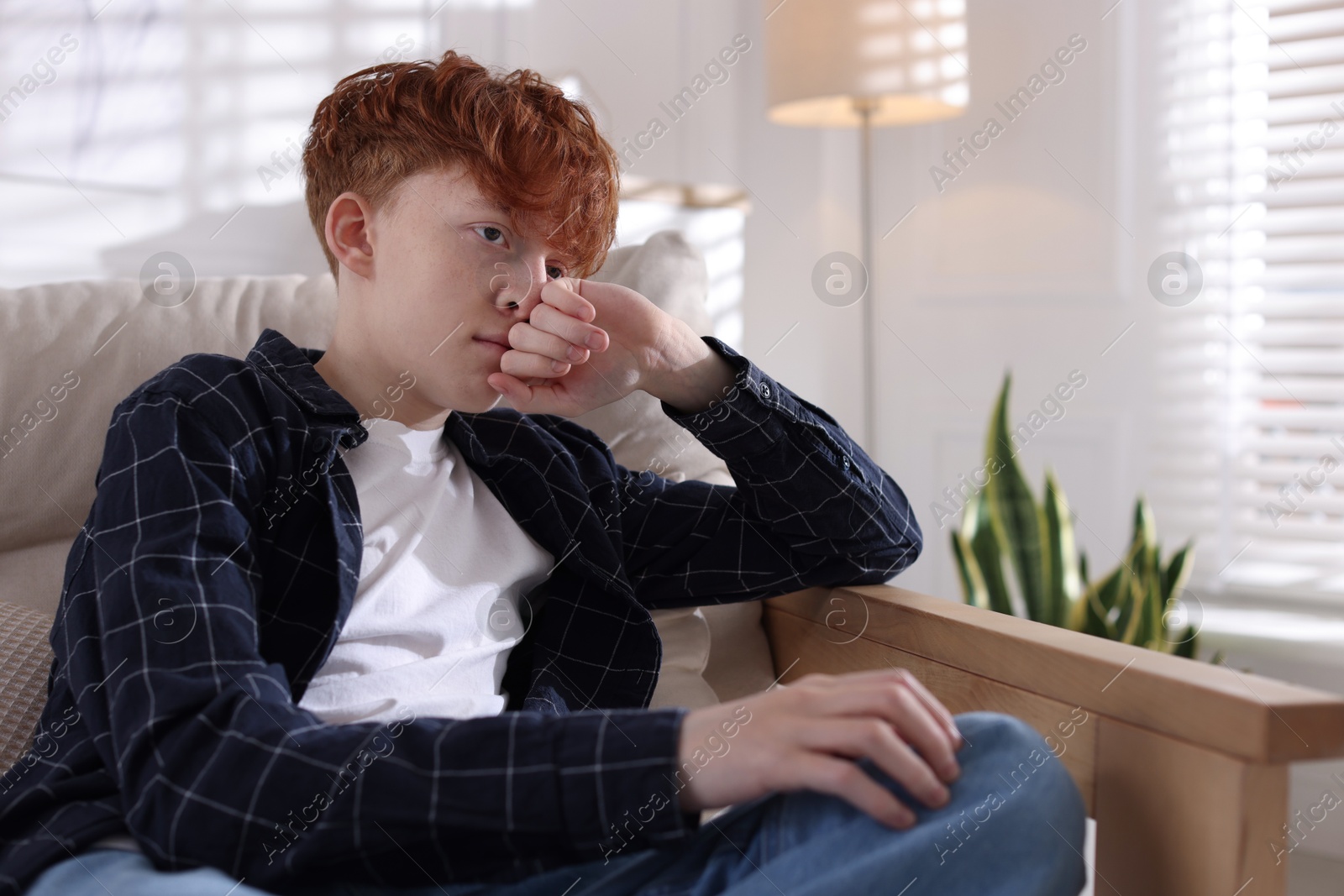 Teen problems. Depressed teenage boy on sofa at home Photo of Teen problems. Depressed teenage boy on sofa at home