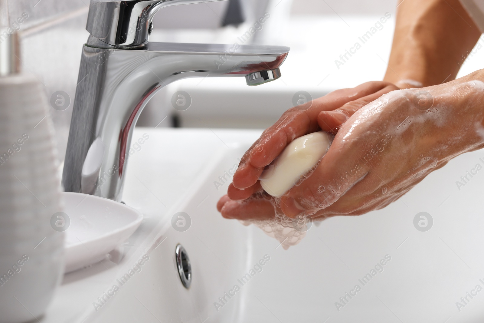 Woman washing her hands with soap above sink in bathroom, closeup Photo of Woman washing her hands with soap above sink in bathroom, closeup